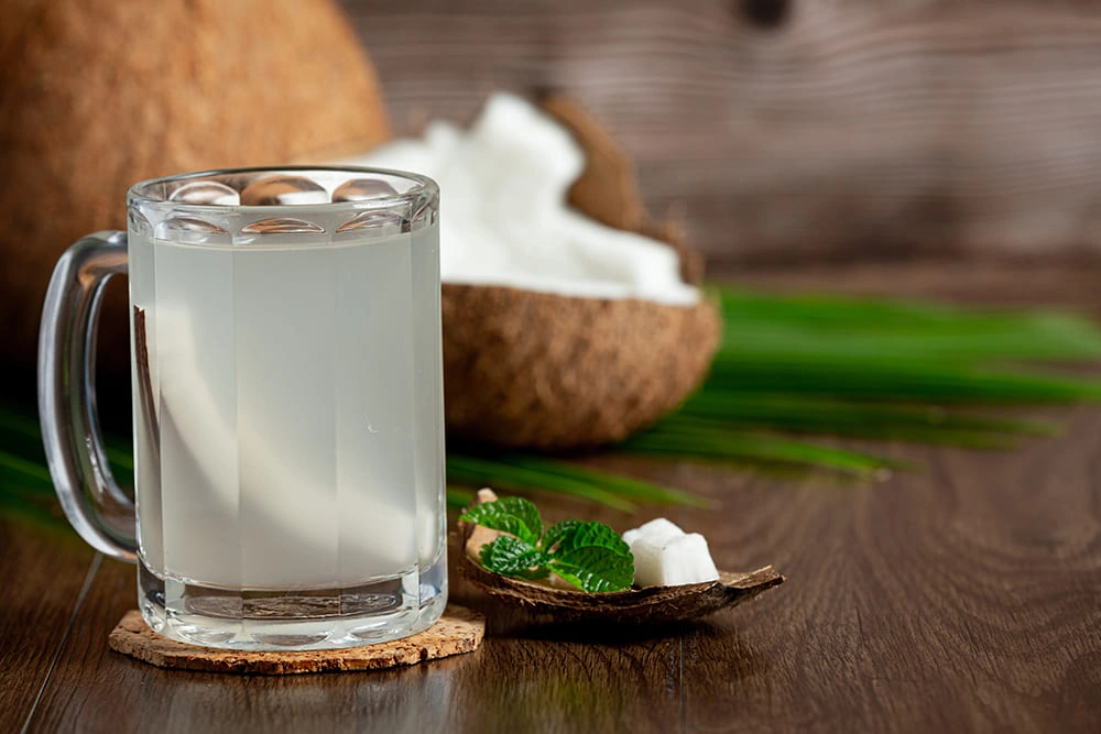 Refreshing coconut water in a glass with coconut slices – a healthy way to drink