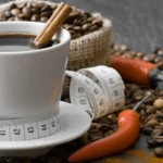 Cup of black coffee with a cinnamon stick, surrounded by coffee beans, red chili peppers, and a measuring tape symbolizing weight loss