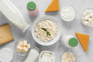 An assortment of dairy products including cottage cheese, milk, butter, and various cheeses on a kitchen counter