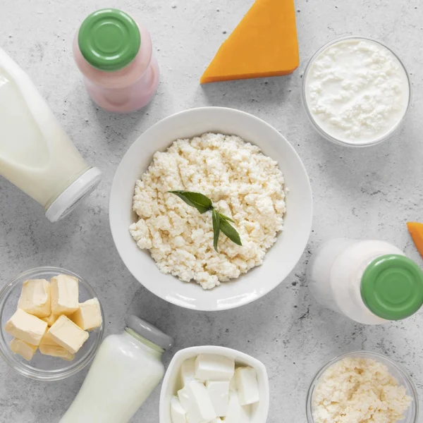 An assortment of dairy products including cottage cheese, milk, butter, and various cheeses on a kitchen counter