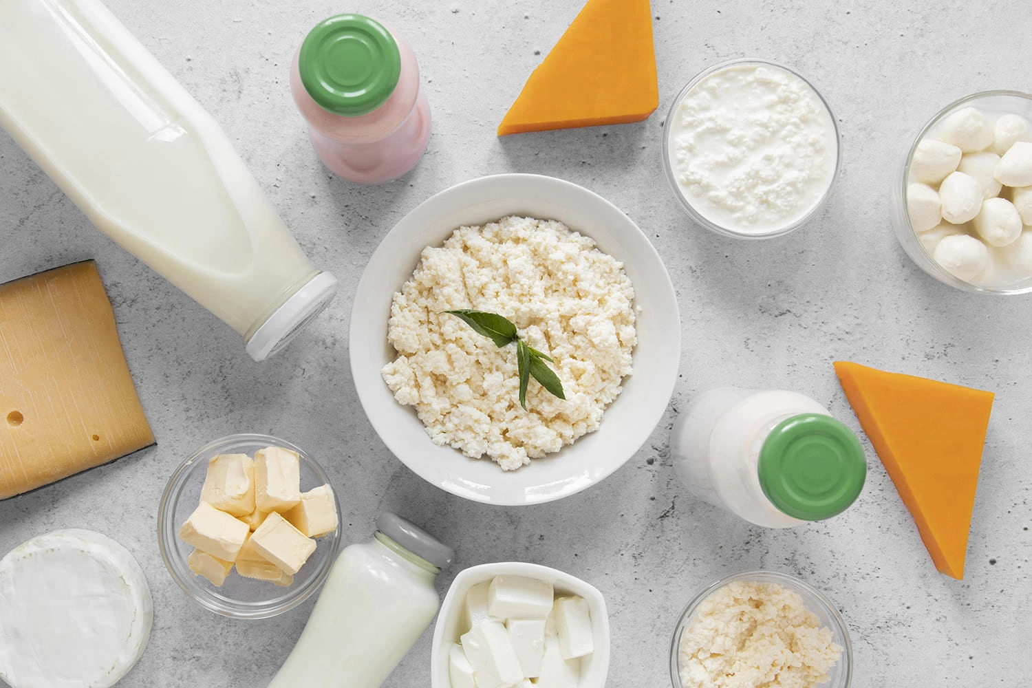 An assortment of dairy products including cottage cheese, milk, butter, and various cheeses on a kitchen counter