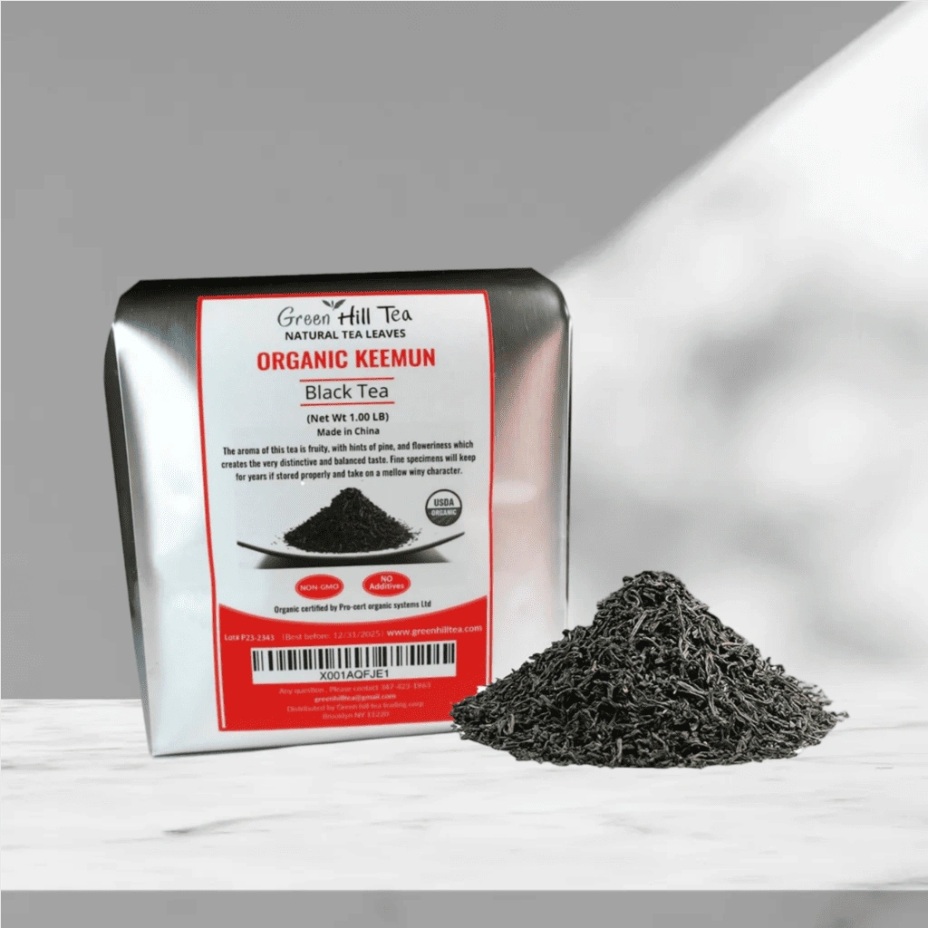 Greenhilltea Organic Keemun Black Tea pouch with loose tea leaves on marble surface