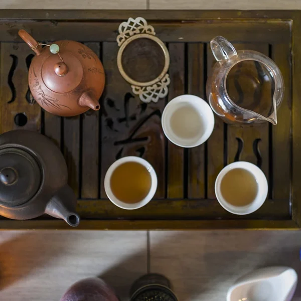 Traditional Chinese tea set with clay teapots and cups on a wooden tray, part of Gongfu tea ceremony